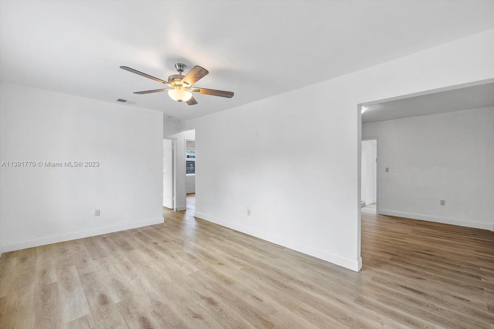 6110 Southwest 20th Street Miami, FL 33155 - Photo 7 of 29 an empty room with wooden floor and a ceiling fan