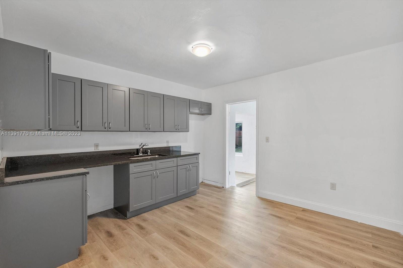6110 Southwest 20th Street Miami, FL 33155 - Photo 8 of 29 a kitchen with granite countertop a sink and a stove top oven