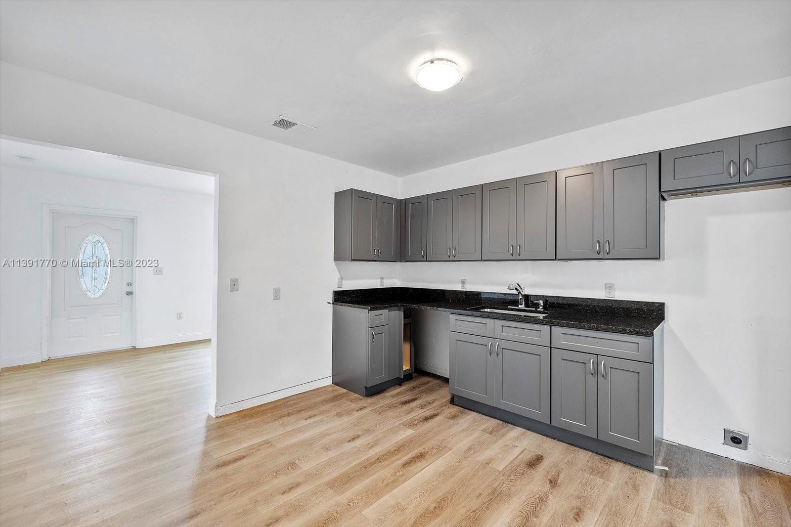 6110 Southwest 20th Street Miami, FL 33155 - Photo 9 of 29 a kitchen with stainless steel appliances granite countertop a sink and wooden cabinets