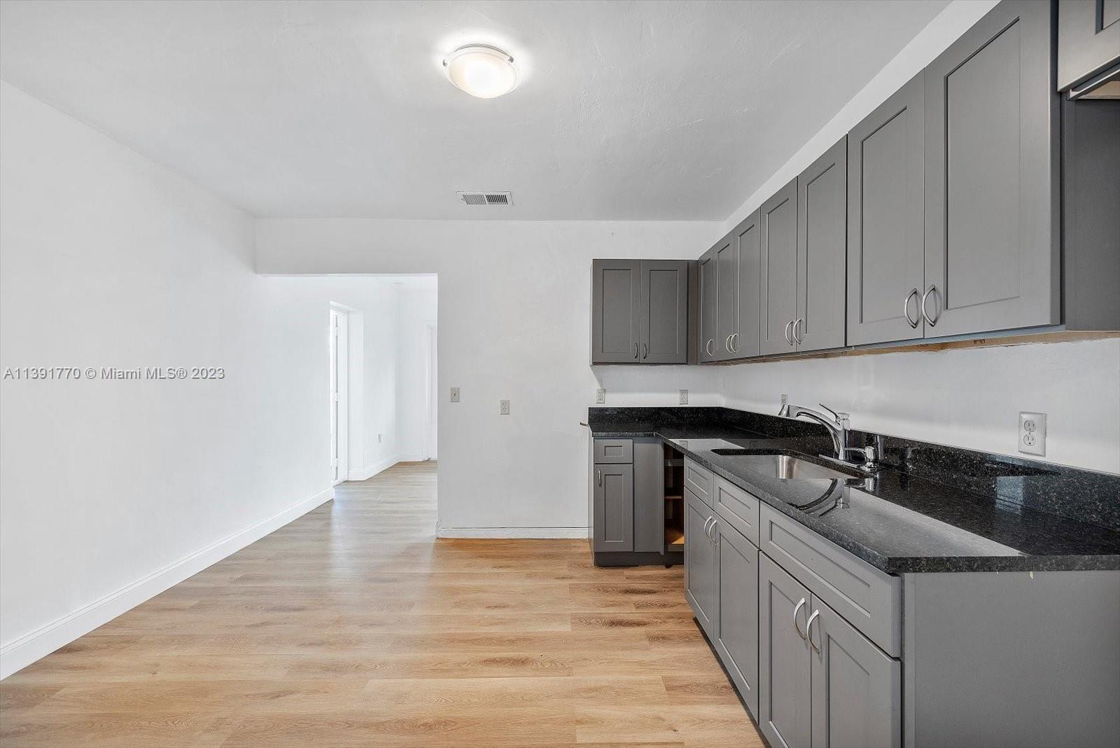 6110 Southwest 20th Street Miami, FL 33155 - Photo 10 of 29 a kitchen that has a sink and cabinets in it