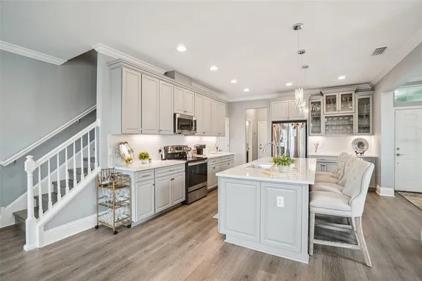 a kitchen with microwave a stove and cabinets