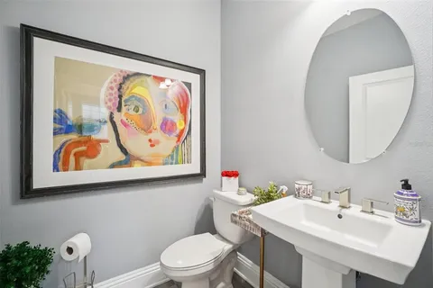 a bathroom with a toilet a sink and a mirror