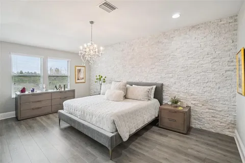 a spacious bedroom with a bed and a chandelier