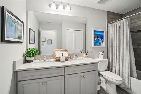 a bedroom with a bed a mirror on desk and a window