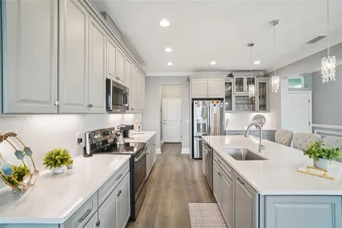 a kitchen with kitchen island granite countertop a sink a stove and refrigerator