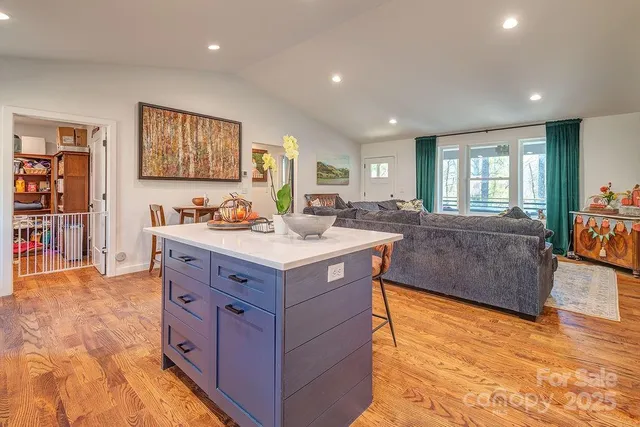 a kitchen with stainless steel appliances granite countertop a sink a stove and a wooden floors