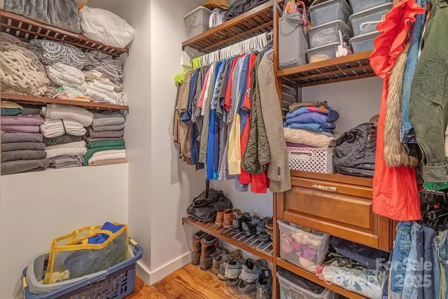 a view of walk in closet with clothes and shoes