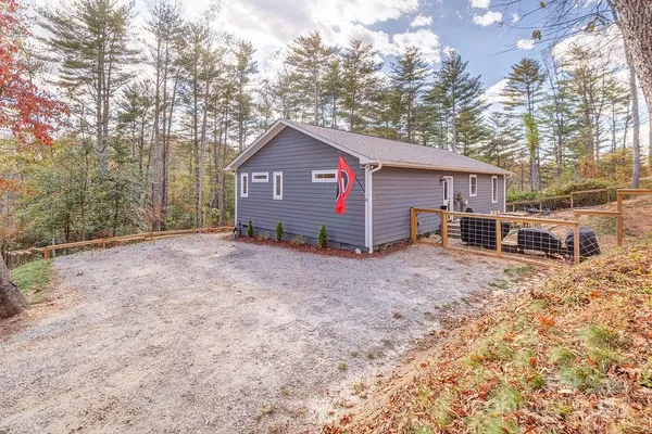 a view of a house with a yard and large trees