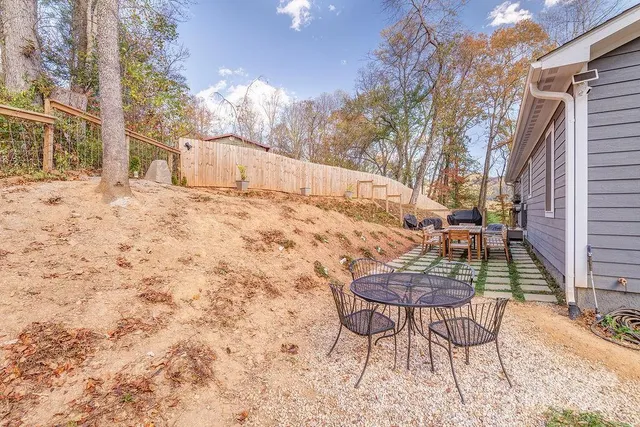 a view of backyard with table and chairs and wooden fence