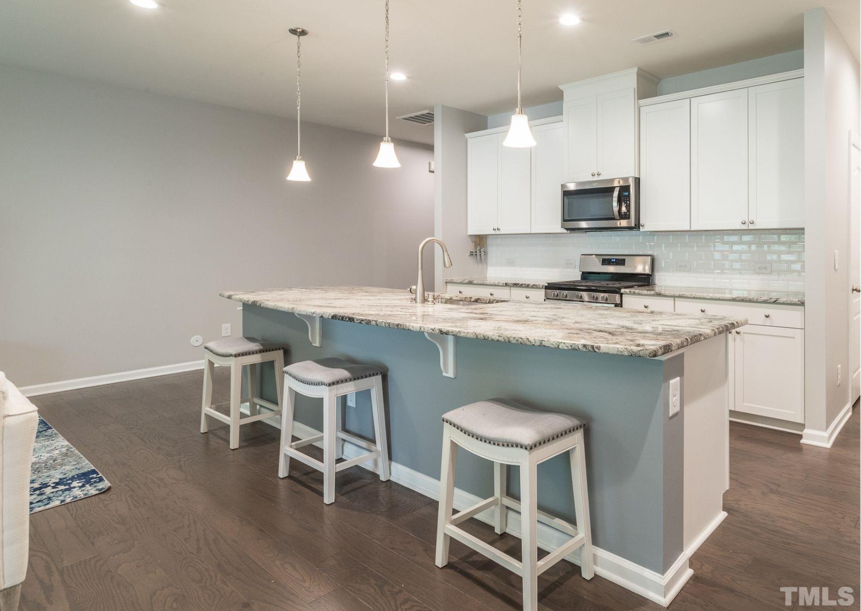 1015 Catch Fly Lane Durham, NC 27713 - Photo 5 of 18 a kitchen with stainless steel appliances granite countertop a white cabinets and chairs