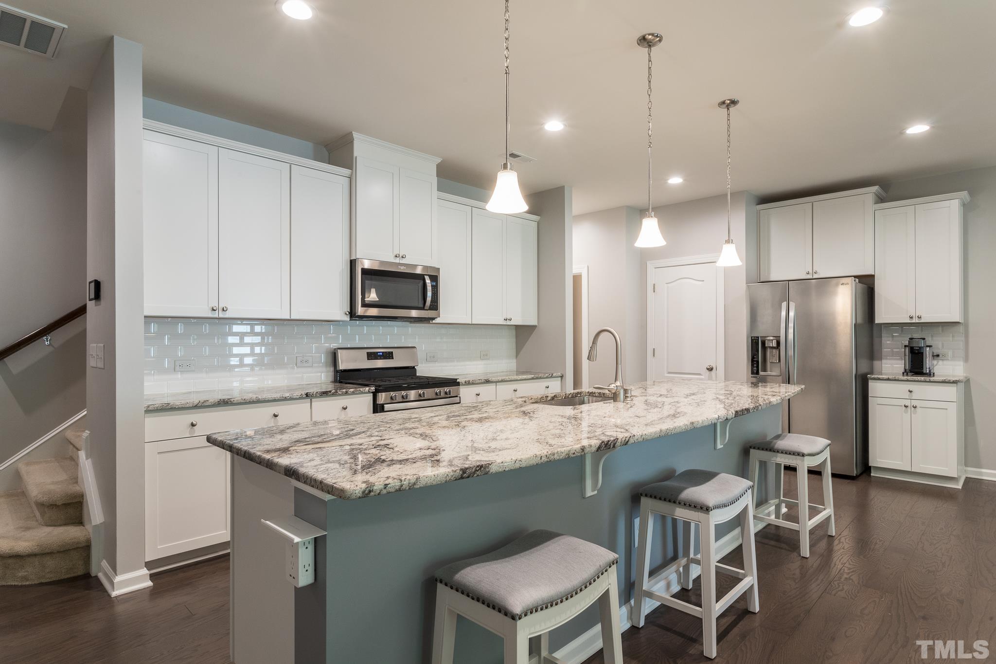 1015 Catch Fly Lane Durham, NC 27713 - Photo 7 of 18 a kitchen with stainless steel appliances granite countertop a sink a stove a refrigerator and island with wooden floor