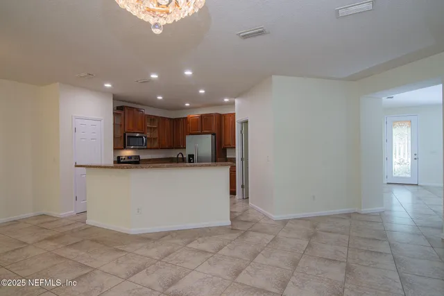 a view of kitchen with stainless steel appliances granite countertop a refrigerator sink and cabinets