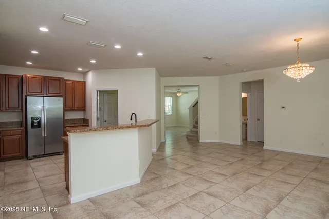 a view of a kitchen with refrigerator and a sink