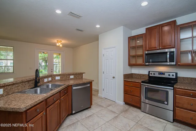a kitchen with stainless steel appliances granite countertop a sink stove and microwave