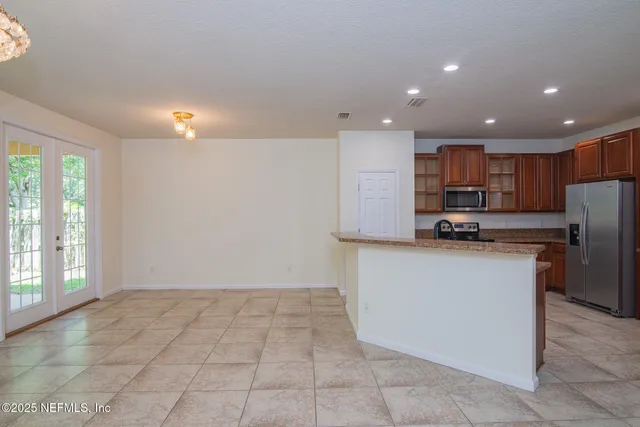 a kitchen with stainless steel appliances granite countertop a refrigerator and a stove