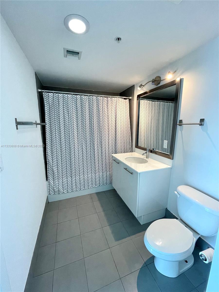 92 Southwest 3rd Street, Unit 4111 Miami, FL 33130 - Photo 15 of 24 a bathroom with a toilet sink and mirror