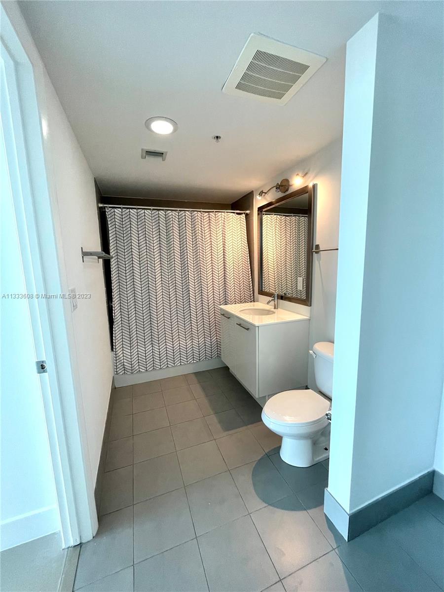 92 Southwest 3rd Street, Unit 4111 Miami, FL 33130 - Photo 16 of 24 a bathroom with a sink toilet and mirror