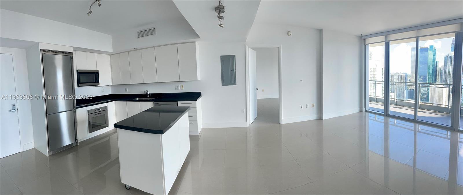 92 Southwest 3rd Street, Unit 4111 Miami, FL 33130 - Photo 4 of 24 a kitchen with granite countertop a refrigerator and a sink