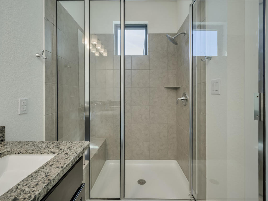 12327 Maypole Bend Austin, TX 78717 - Photo 24 of 30 a bathroom with a granite countertop sink a shower and a mirror
