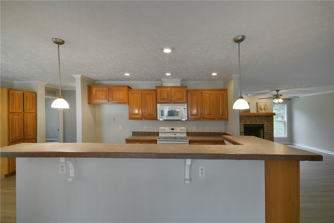579 Daventon Road Honea Path, SC 29654 - Photo 3 of 44 A well-appointed kitchen features ample cabinetry and a convenient breakfast bar, flowing into a comfortable living space with a fireplace.
