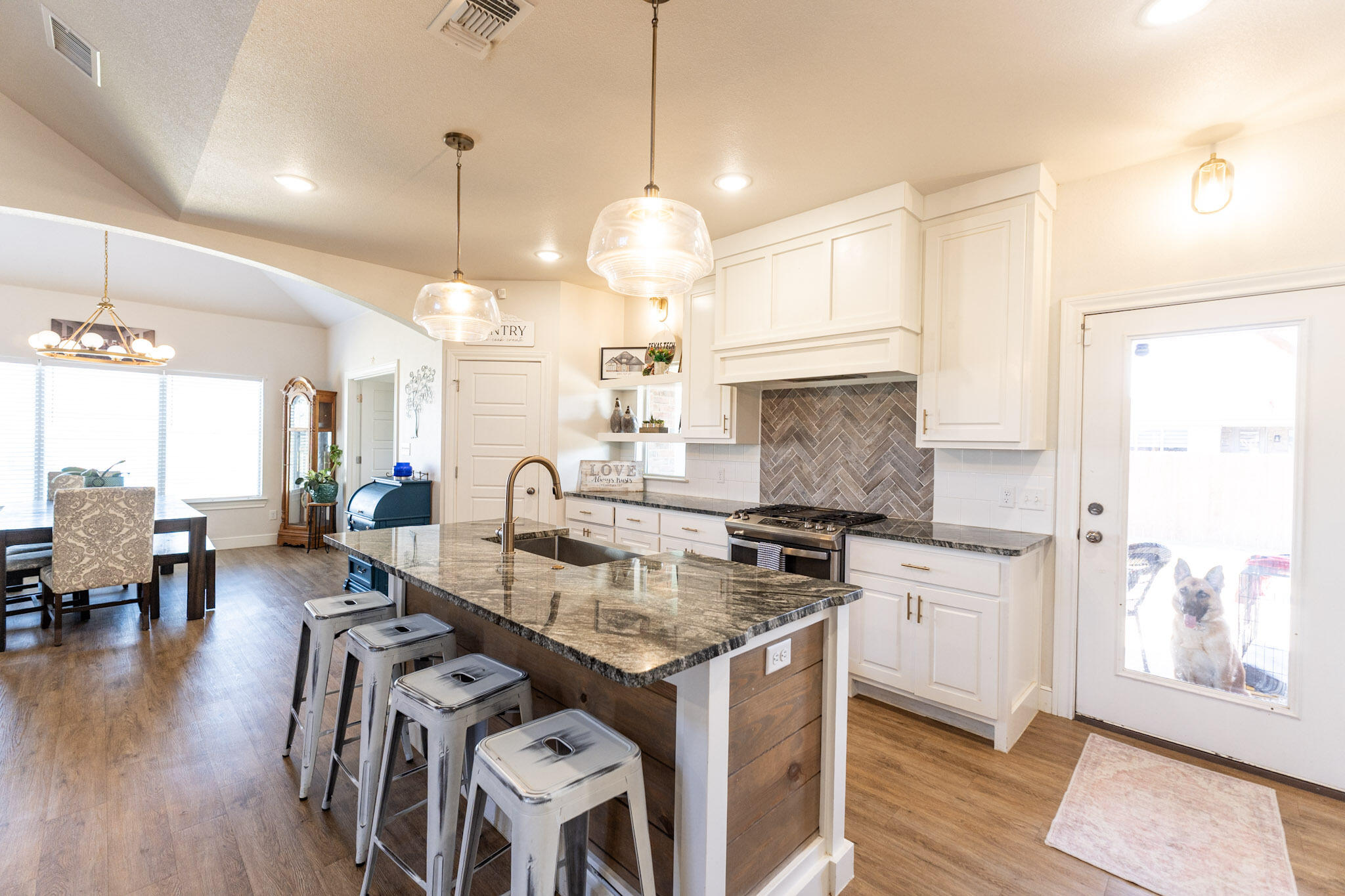 6801 51st Street Lubbock, TX 79407 - Photo 5 of 19 a kitchen with stainless steel appliances granite countertop a stove and a view of living room with wooden floor