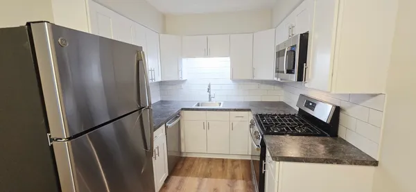 a kitchen with granite countertop a refrigerator and a sink