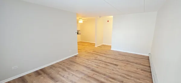 a view of empty room with wooden floor