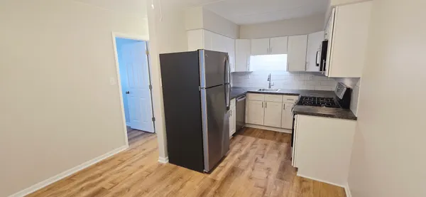 a kitchen with a refrigerator cabinet and a sink