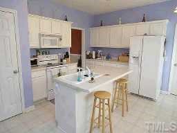 127 Saddle Ridge Drive Willow Spring, NC 27592 - Photo 5 of 10 a kitchen with stainless steel appliances a sink a stove a refrigerator and cabinets