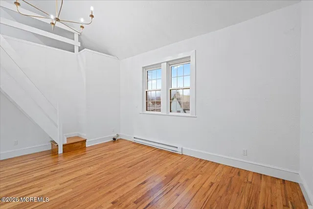 a view of a room with wooden floor and white walls
