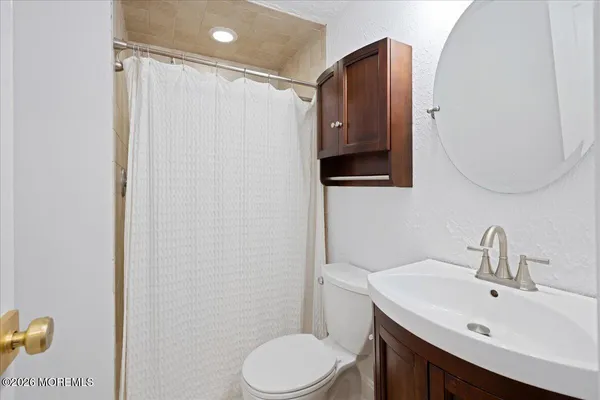 a bathroom with a sink vanity mirror and toilet