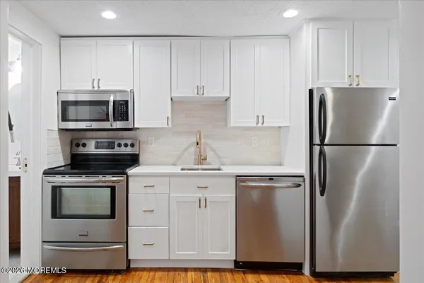 a kitchen with appliances a refrigerator and cabinets