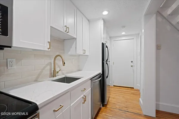a kitchen with stainless steel appliances a sink and a refrigerator