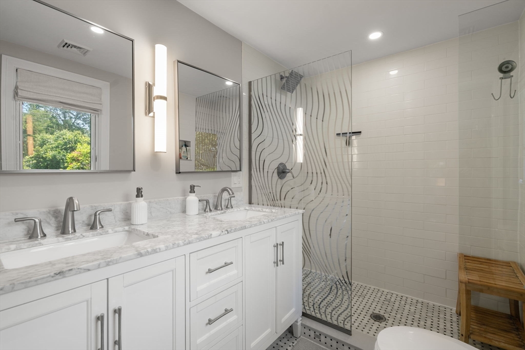 10 Brookdale Road Natick, MA 01760 - Photo 11 of 19 a bathroom with double vanity sink a mirror a toilet and shower