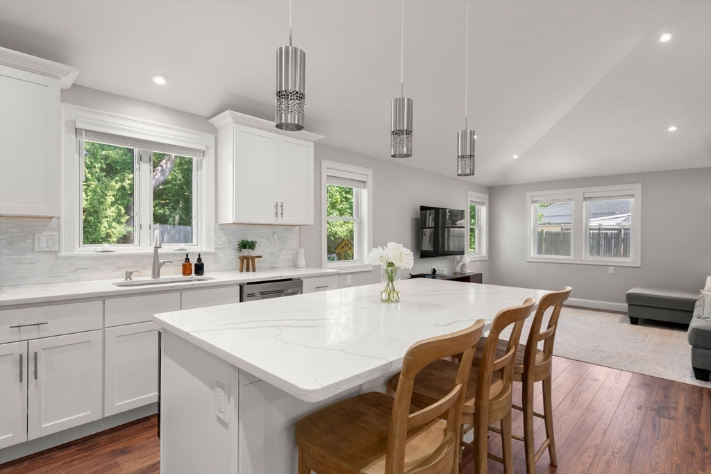 10 Brookdale Road Natick, MA 01760 - Photo 7 of 19 a kitchen with stainless steel appliances kitchen island granite countertop a stove a sink a dining table and chairs