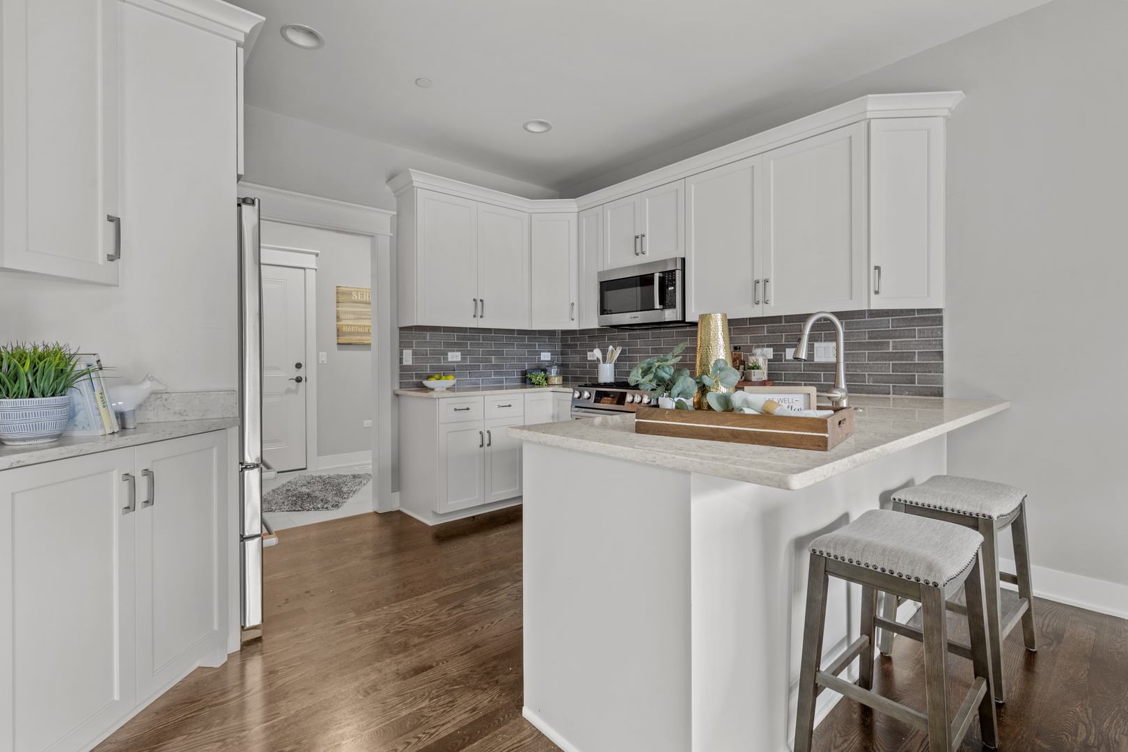 613 Bourbon Lane Naperville, IL 60565 - Photo 7 of 36 a kitchen with white cabinets and stainless steel appliances