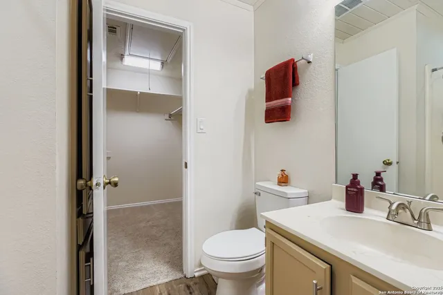 a bathroom with a sink vanity mirror and toilet
