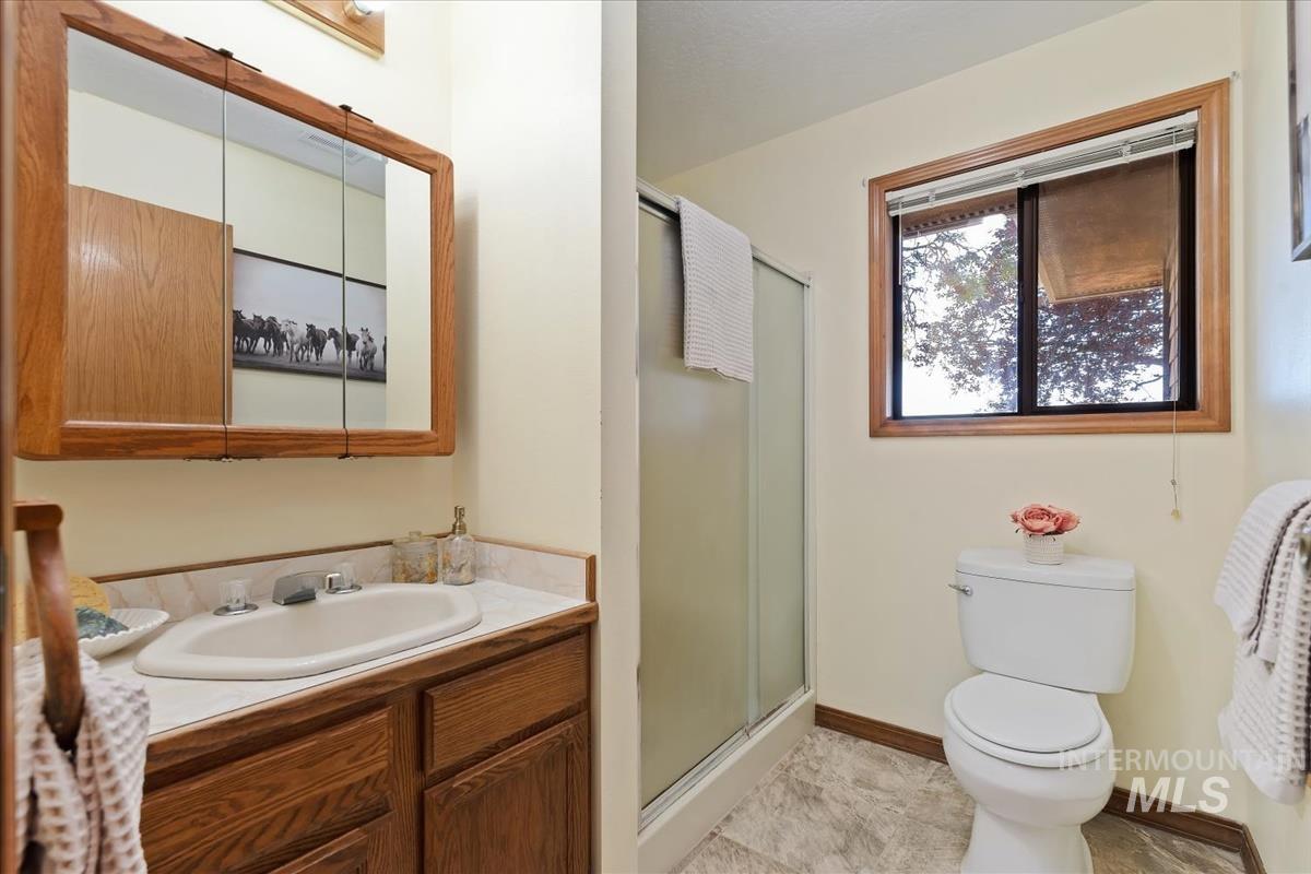 8275 Washoe Road Fruitland, ID 83619 - Photo 24 of 43 Oak-finish vanity with an integrated sink and light-toned countertop