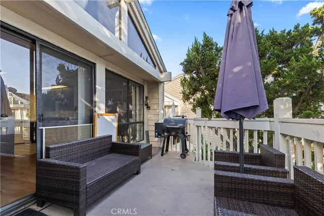 a view of a roof deck with chair and wooden fence