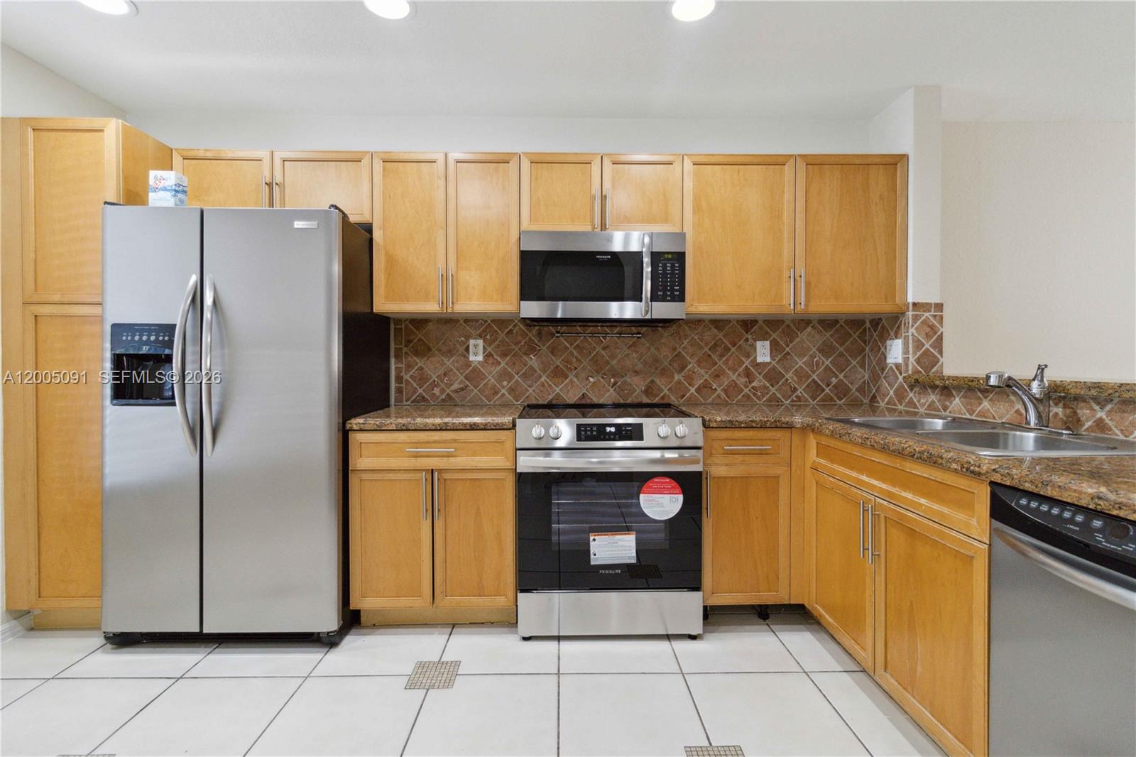 3079 Southwest 129th Way, Unit 159 Miramar, FL 33027 - Photo 11 of 44 a kitchen with stainless steel appliances granite countertop a refrigerator and a stove top oven