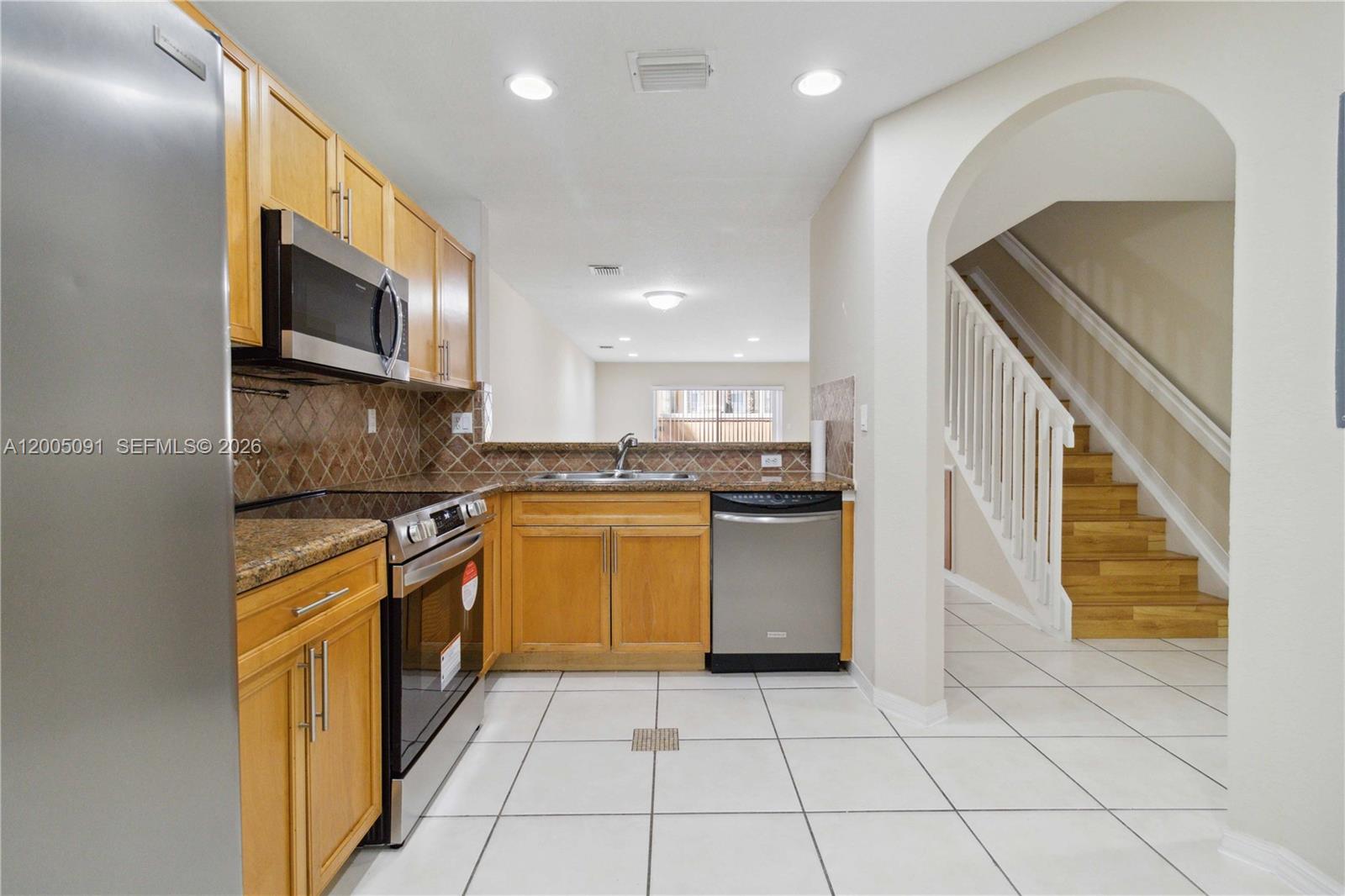 3079 Southwest 129th Way, Unit 159 Miramar, FL 33027 - Photo 12 of 44 a kitchen with stainless steel appliances granite countertop a refrigerator a stove top oven and sink