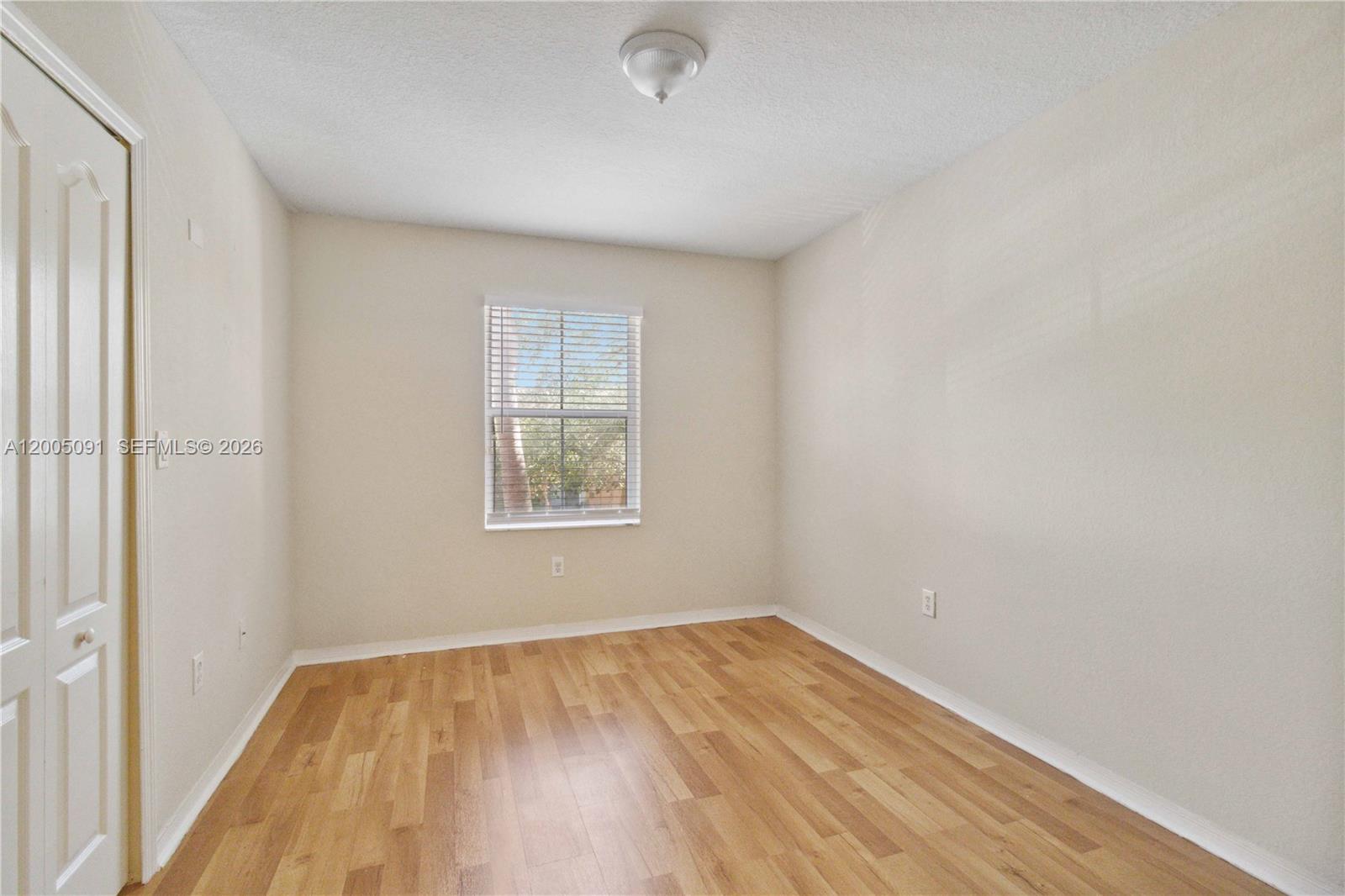 3079 Southwest 129th Way, Unit 159 Miramar, FL 33027 - Photo 17 of 44 an empty room with wooden floor and windows