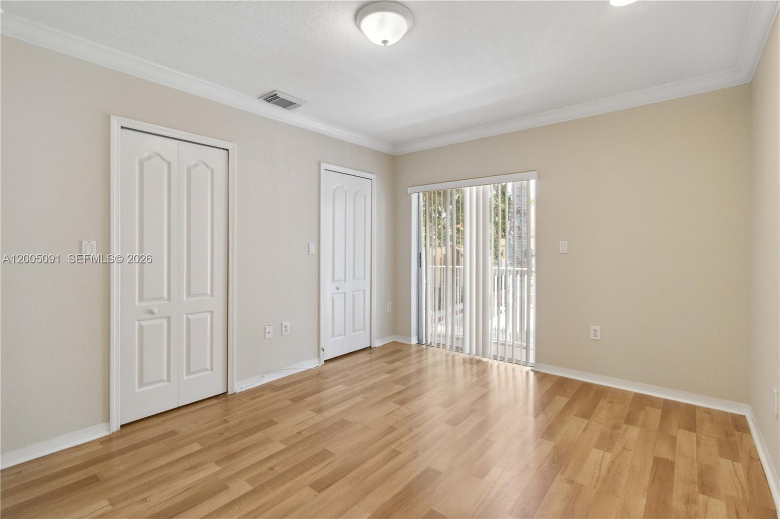 3079 Southwest 129th Way, Unit 159 Miramar, FL 33027 - Photo 22 of 44 a view of an empty room with wooden floor and a window