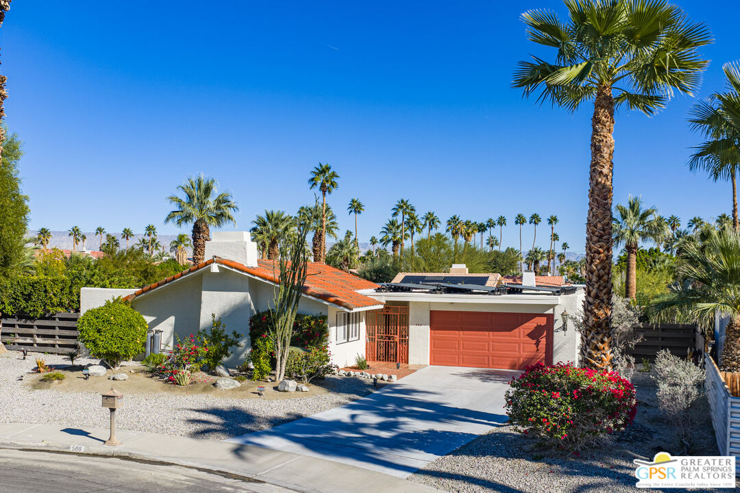 566 North Sunset Way Palm Springs, CA 92262 - Photo 2 of 39 a front view of a house with a big yard and potted plants
