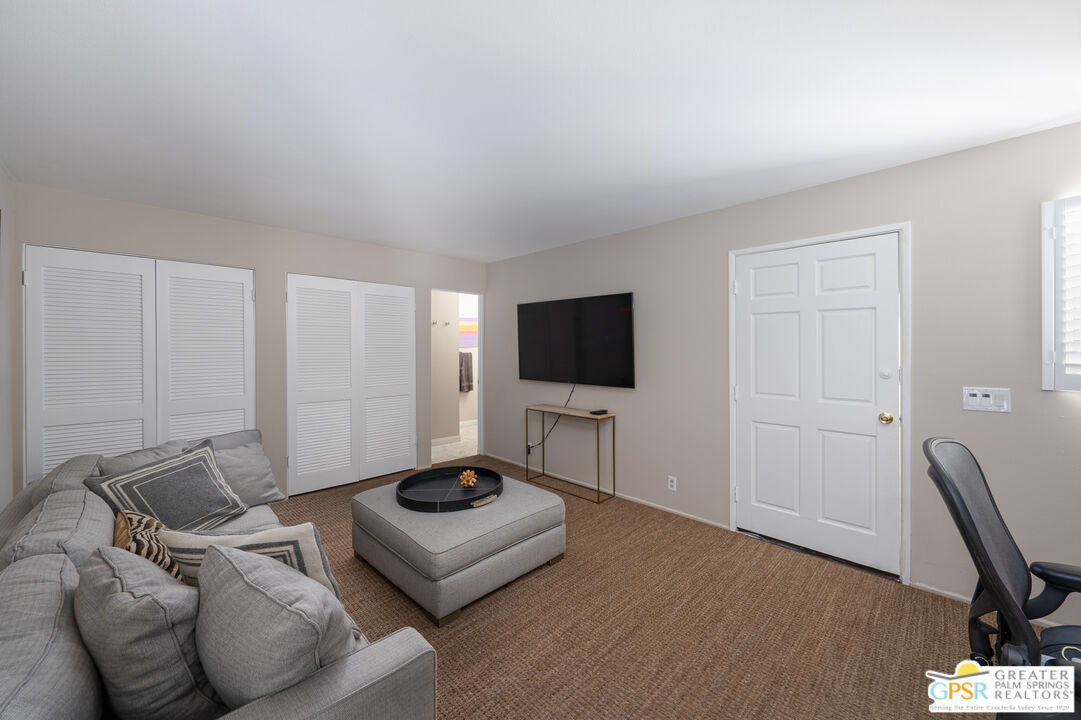 566 North Sunset Way Palm Springs, CA 92262 - Photo 25 of 39 a living room with furniture and a flat screen tv