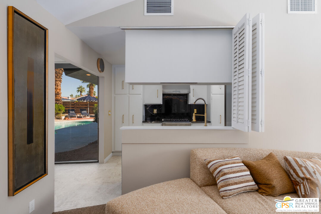 566 North Sunset Way Palm Springs, CA 92262 - Photo 8 of 39 a living room with a couch and a kitchen view