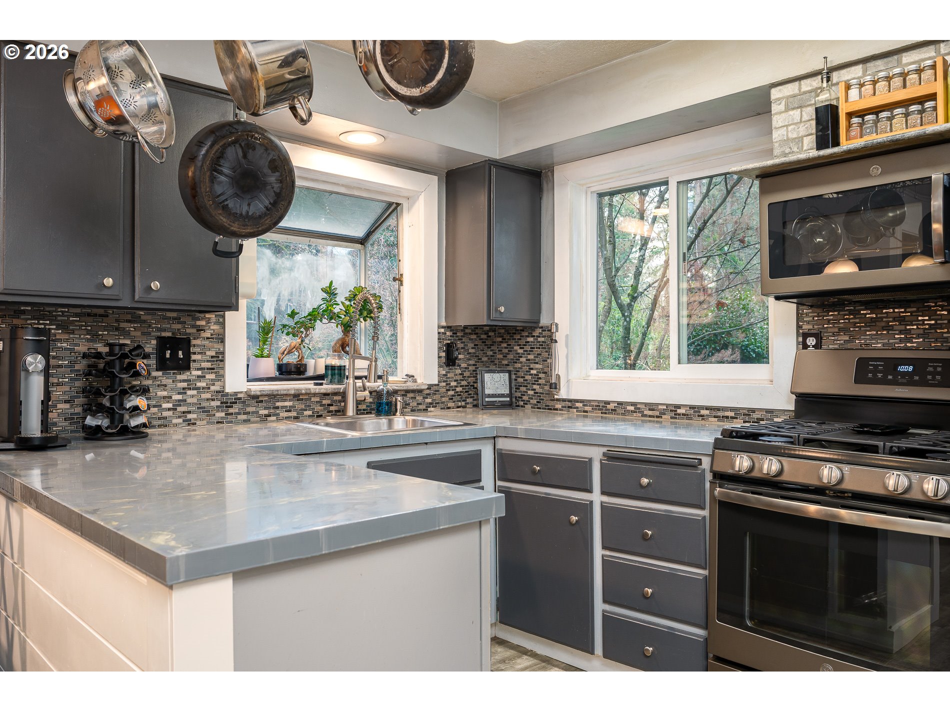 2685 Southwest 89th Avenue Portland, OR 97225 - Photo 16 of 37 a kitchen with kitchen island granite countertop a stove a sink and a microwave