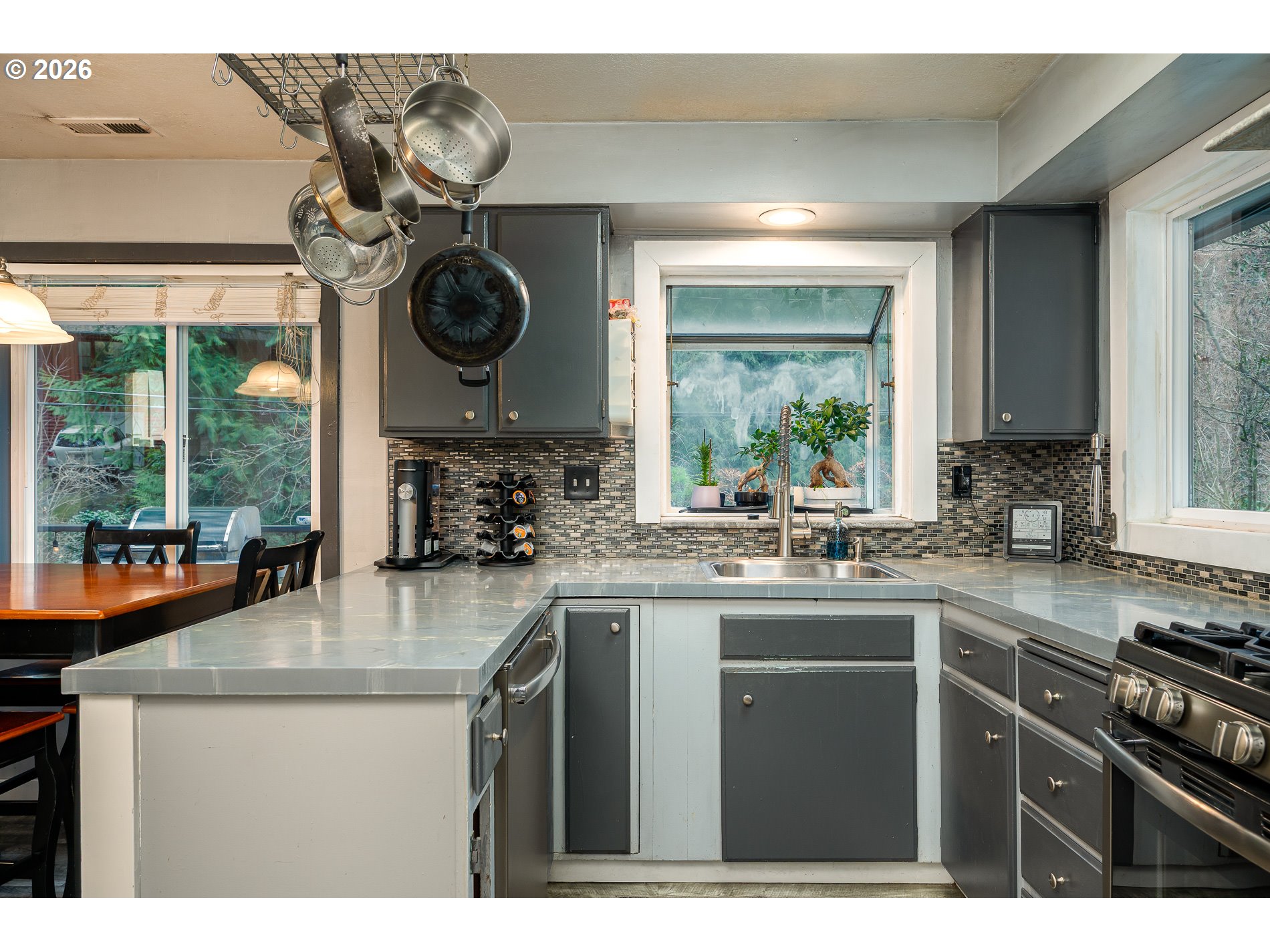 2685 Southwest 89th Avenue Portland, OR 97225 - Photo 17 of 37 a kitchen with stainless steel appliances granite countertop a sink a stove and a wooden floors