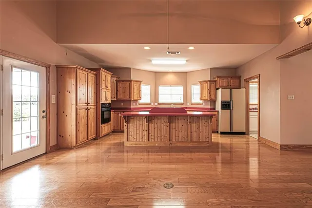 a view of empty room with wooden floor and fireplace