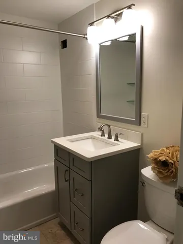 a bathroom with a sink and mirror with bathtub
